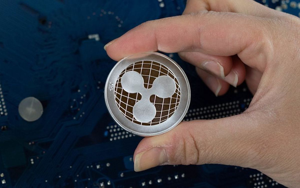 moneta Ripple tenuta tra pollice e indice