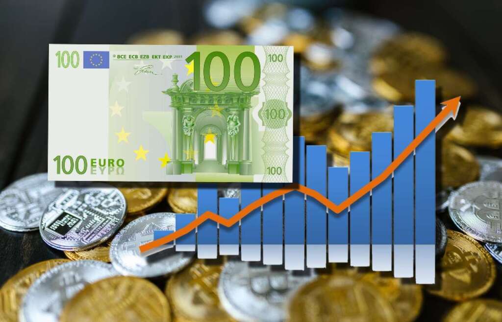 un piano ricoperto di monete di Bitcoin color oro e argento, con una banconota da 100 euro in sovrimpressione insieme a un grafico