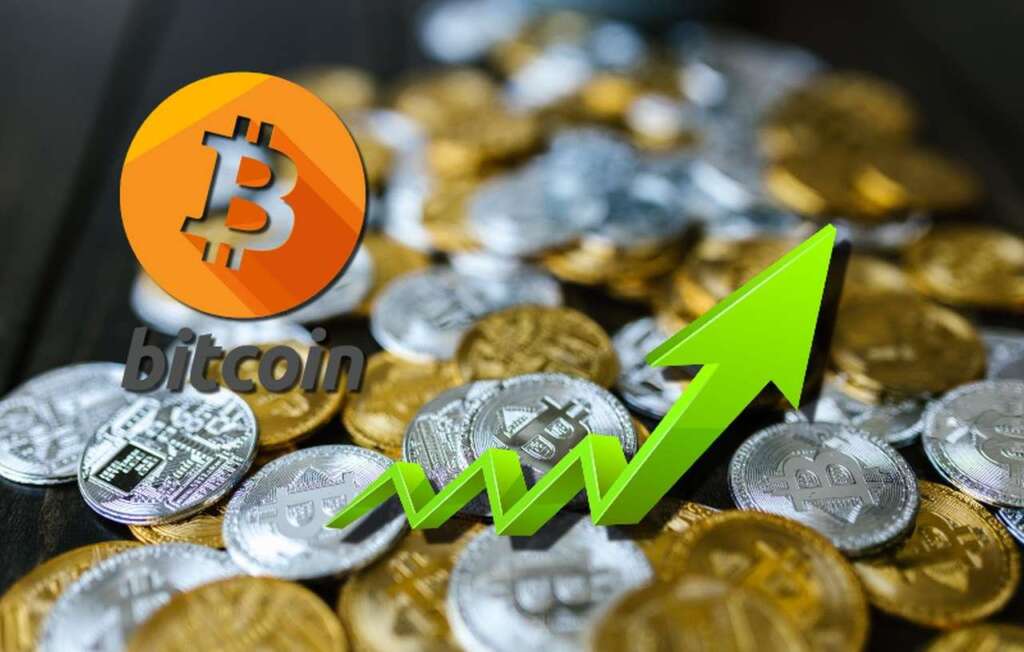 monete di Bitcoin d'oro e d'argento sparse su un piano. Il logo di Bitcoin e una freccia in sovrimpressione