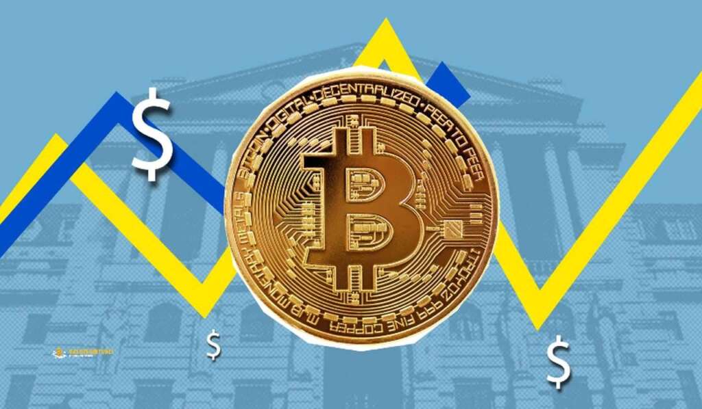 Una moneta di Bitcoin e sullo sfondo le linee di un grafico in giallo e blu
