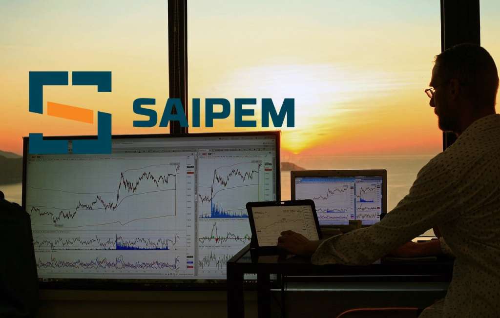 schermi con grafici di trading e logo di Saipem