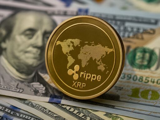 Una moneta con in piccolo il simbolo di XRP e una mappa del mondo. Sullo sfondo delle banconote