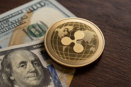 Una moneta di XRP poggiata su un piano con delle banconote